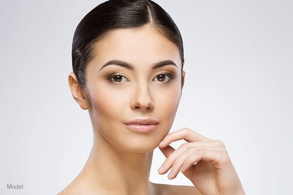 Headshot of a woman caressing her cheek