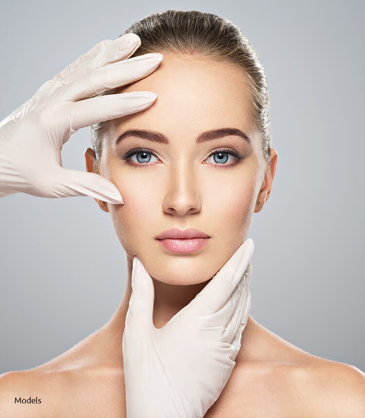 Headshot of a woman's face getting examined by gloved hands